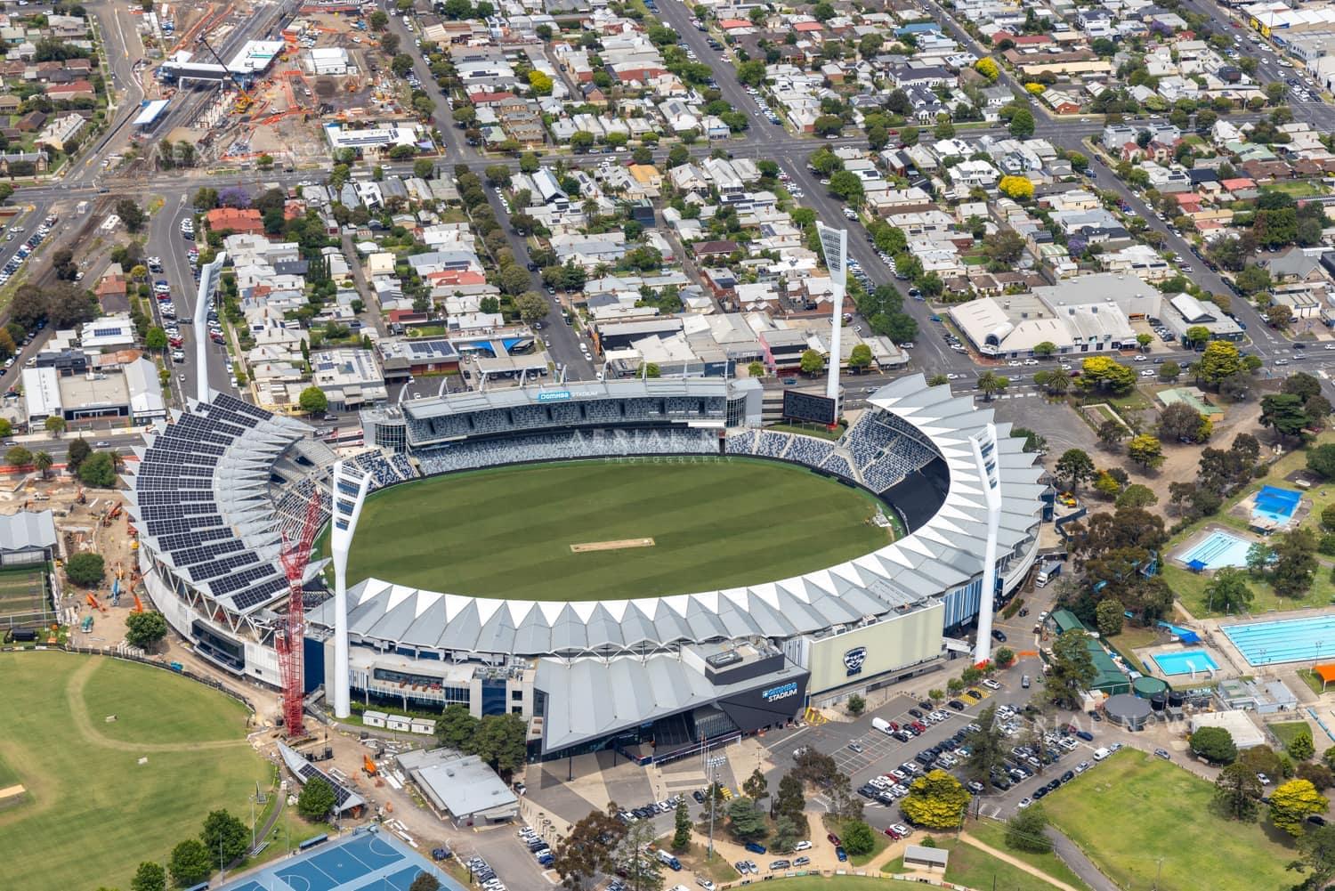 Aerial view of GMHBA Stadium within Kardinia Park in South Geelong, with grandstands, the oval, surrounding car parks, sports fields and residential streets visible.