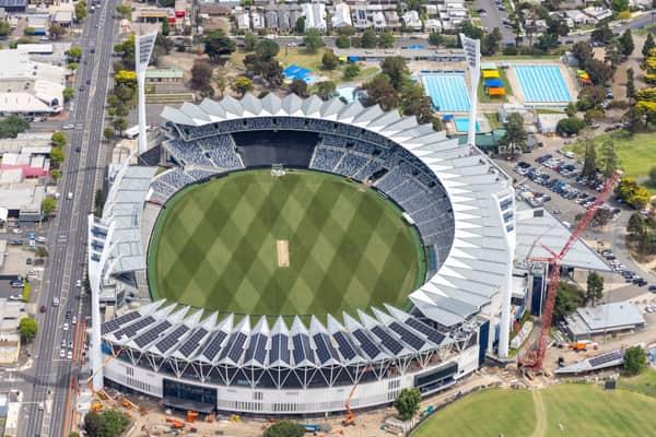 Aerial view of GMHBA Stadium at Kardinia Park in South Geelong, showing the oval, grandstands, light towers, nearby Moorabool Street, aquatic centre pools and construction activity.