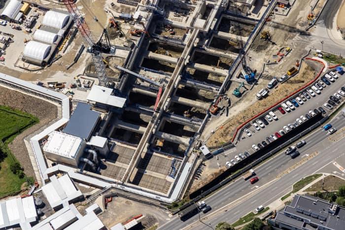 Aerial view of the North East Link construction site beside Bulleen Road in Bulleen, showing excavated concrete works, cranes, machinery, parked vehicles and traffic.