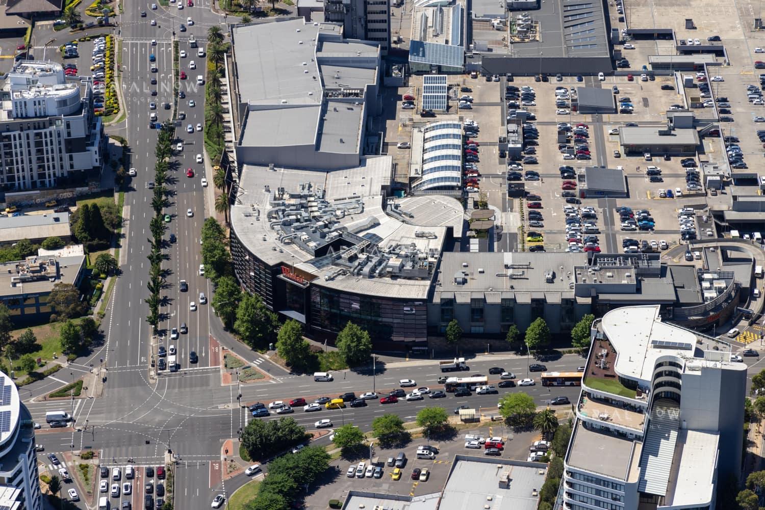Aerial view of Westfield Doncaster in Doncaster VIC, showing rooftop parking, surrounding commercial buildings, Doncaster Road traffic and nearby intersections.