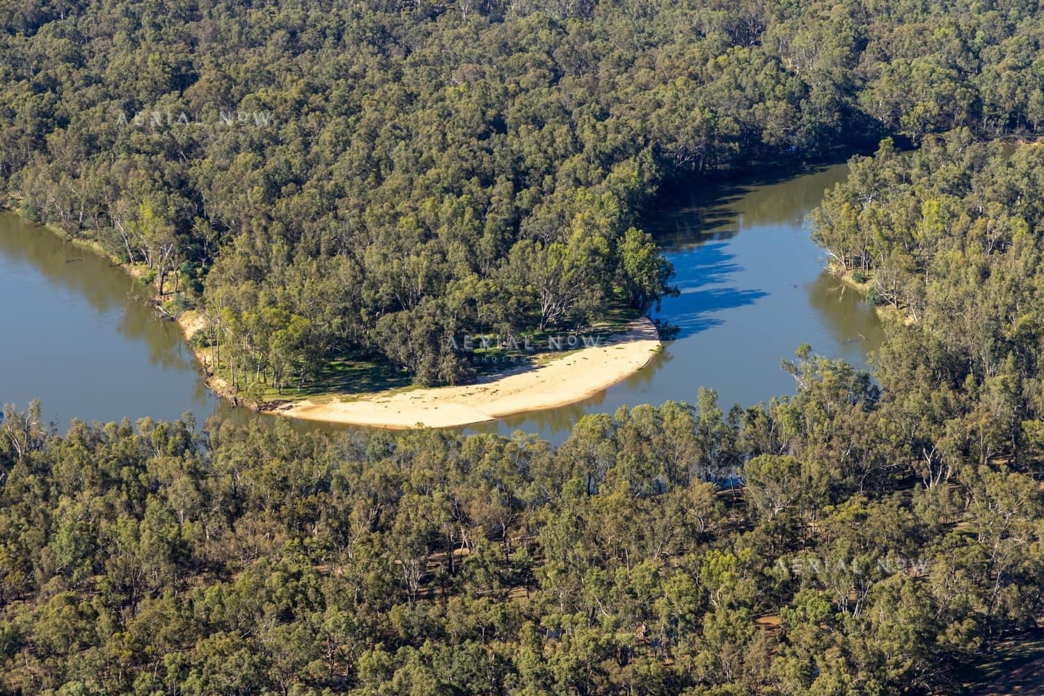 Aerial view of the Murray River curving around a sandy point bar amid dense riparian woodland at Cobram East, Victoria.