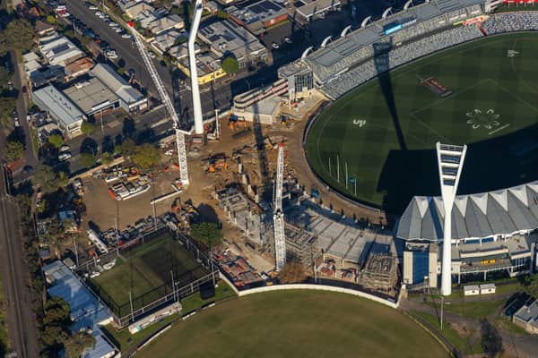 Aerial view of GMHBA Stadium and Kardinia Park in South Geelong with tower cranes, construction works, grandstands and surrounding sports fields visible.