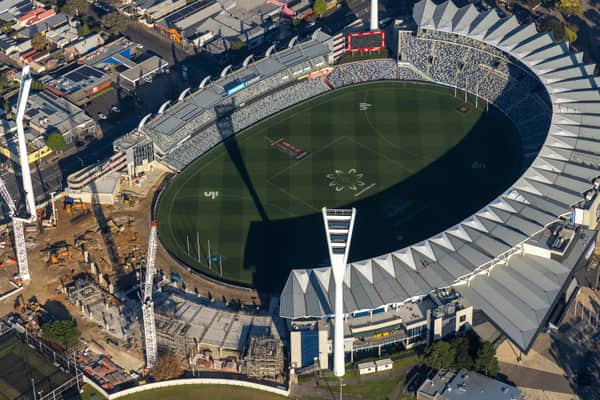Aerial view of GMHBA Stadium at Kardinia Park in South Geelong with cranes, construction works, existing stands and the oval playing surface visible.