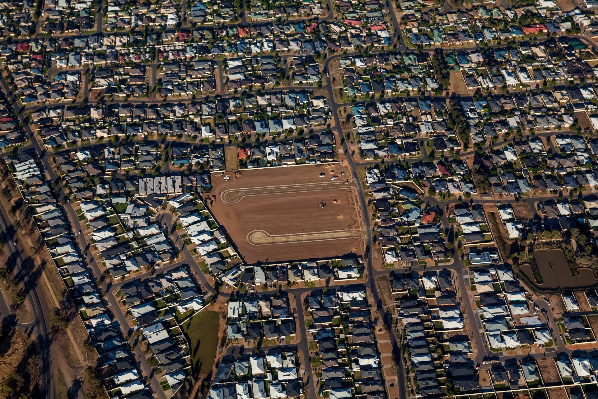 Aerial photo of a new residential housing development with road outlines, surrounded by existing suburban homes, Melbourne