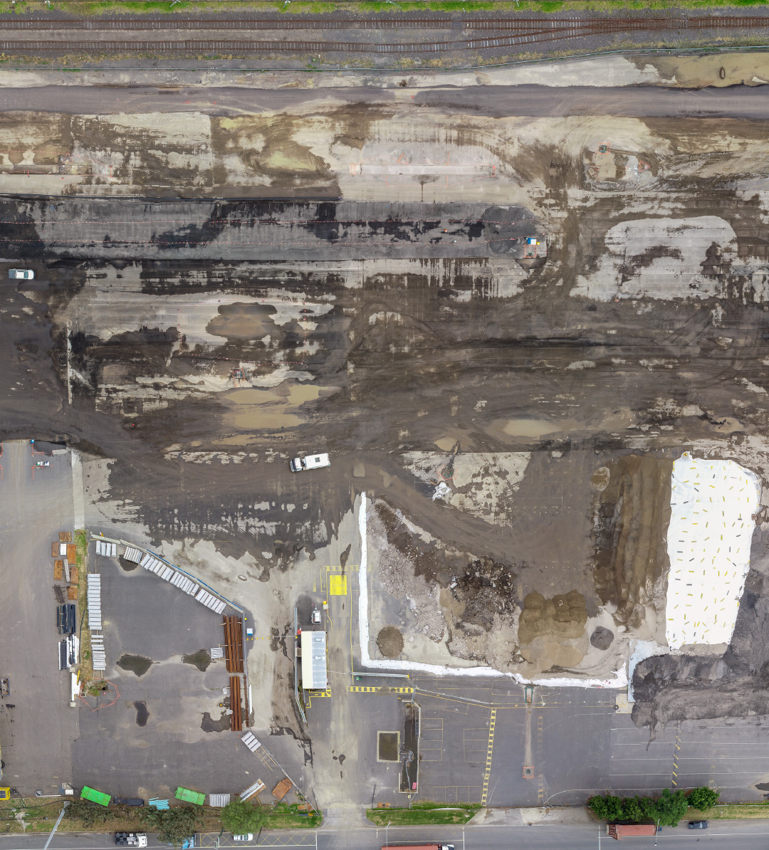 Aerial view of a residential construction site with organised building materials and earthworks, Melbourne